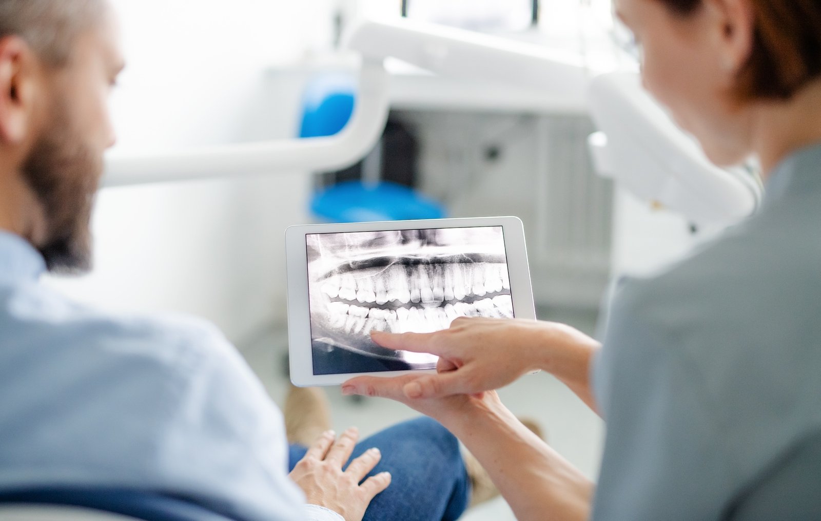 Rear view of man and dentist in dental surgery, annual check-up